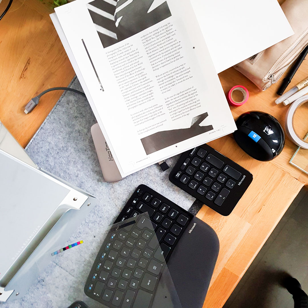 Image shows workspace with coursework and keyboard lying on top.